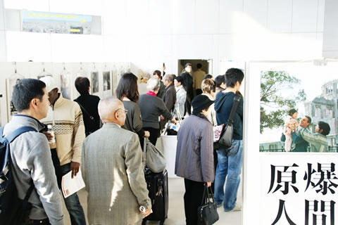 東京原爆展入り口。多数の来場者が足を止めて展示に見入る。