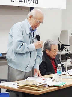 講師の写真。立ってマイクを持ち講演している吉田一人さんと、隣で着席し資料に目を落としている山本英典さん