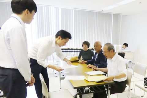東友会の代表と、広島市職員が書類を確認している。