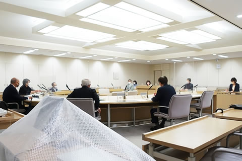 長円形に並べられた机に間隔を置いて座る議員らと東友会の参加者たち。