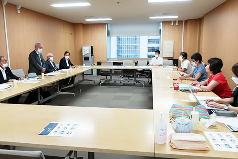 長円形に並べられた机に間隔を置いて座る議員らと東友会の参加者たち。