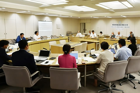 大文字の「D」型に並べられた机に座り、向かい合う議員らと東友会の参加者たち。
