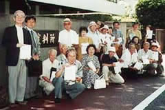 東京地裁前に並ぶ署名提出参加者ら。