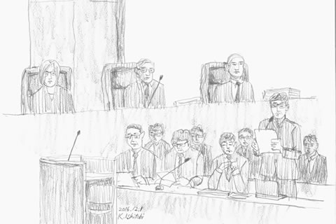 法廷のスケッチ。上半分を使って着席した裁判官3名が、下半分をつかって被爆者側席の弁護士らが描かれている。弁護士のうち一人がマイクを持ち、書類を見ながら発言している場面。
