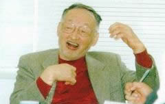 椅子に座り、身振りを交えて話す、森川靖夫・元早稲田大学教授。