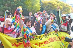 横断幕を広げ、折り鶴を手に持って高く掲げる参加者たち。