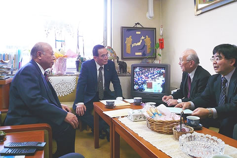 机を囲んで座る要請参加者と国民新党の亀井副代表。