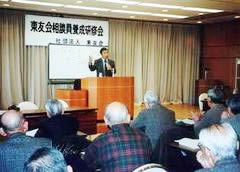 会場前方の演台に立ち講演する安原幸彦弁護士と、並べられた机に着席しそれを聞く参加者たち。
