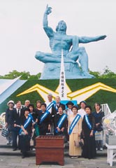 たすきを掛けた被爆者をはじめとした東友会代表らが平和祈念像前に立っている。