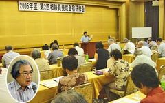 並べられた机に着席し講演を聞く参加者と、講師の山本副会長。