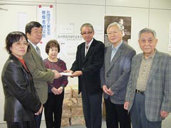 東友会事務所前にて、募金を受け取る横川会長と東友会役員。