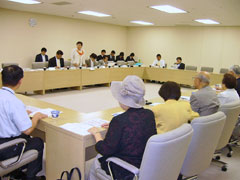 長方形に並べられた机に着席し話し合う議員団と東友会役員ら。