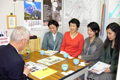 東友会事務所内で、机をはさんで談笑する岩波書店労組の方と東友会役員。