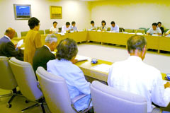 長方形に並べられた机に着席し話し合う、民主党の都議会議員らと東友会の参加者ら。