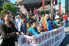 「全ての戦争被害者・遺族に補償を」の横断幕を先頭に浅草の町を行進する参加者たち。