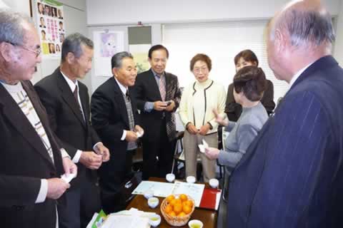 長崎被爆地域拡大連絡会の代表と東友会役員らが机を挟んで立ち、話をしている