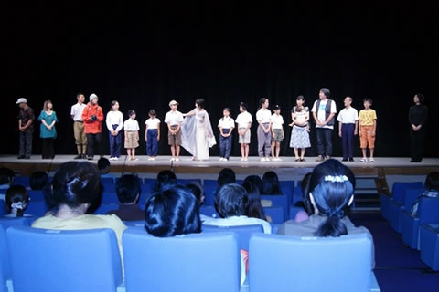 ステージの上に、子どもたちが横一列に並んで立っている。
