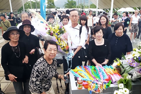 長崎平和公園に設置された献花台の前に並ぶ代表団。