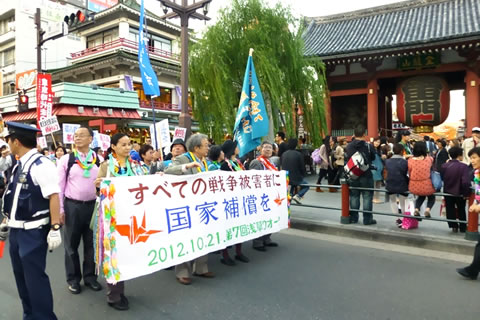 雷門前の車道で、「全ての戦争被害者に国家補償を」の横断幕を掲げている参加者たち。