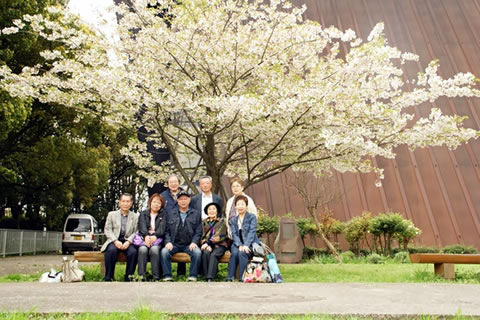 八重桜の前のベンチに座る人たち