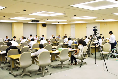 並べられた机に着席する報道機関の人びとと、向き合って着席する専門家と東友会役員ら。