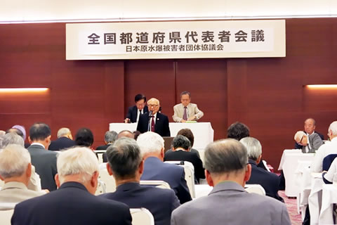 「全国都道府県代表者会議」の看板が下げられた会場で、報告を聞く参加者