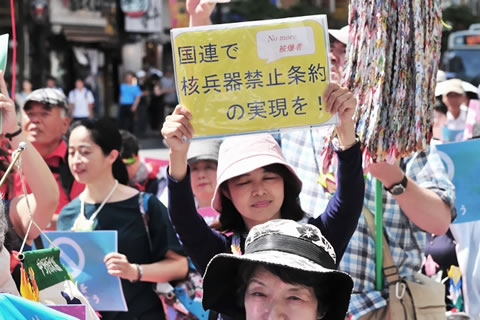 「国連で核兵器禁止条約の実現を！」と大きく書かれたパネルを頭上に掲げるパレード参加者。