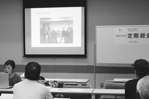 定期総会で、スライドを上映しながら報告する山田さん。