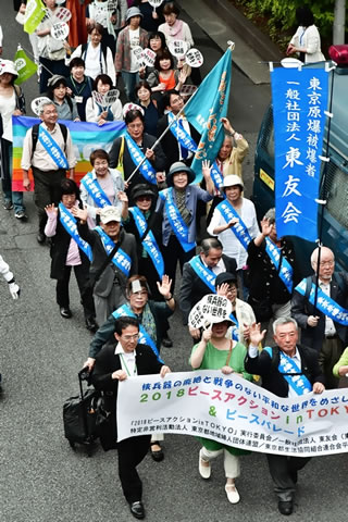 渋谷の街を歩く被爆者たち。たすきを掛け、東友会ののぼりを持っている人や旗を持っている人もいる。