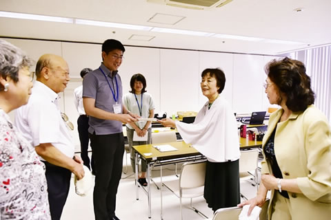 東友会の代表と、手渡しで名簿を受け取る広島市職員。