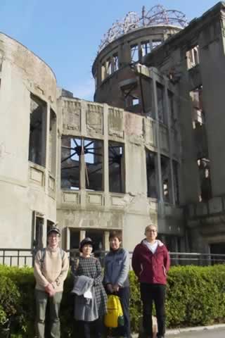 原爆ドームを背後に立つ4人のツアー参加者