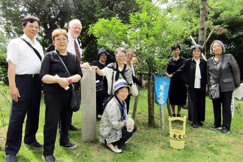 「東京の木」の周りに立つ参加者たち。