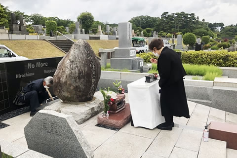 「原爆被害者の墓」前にしつらえられた献花台の前で手を合わせる参加者