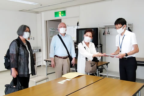 広島市職員に書類を手渡している場面。