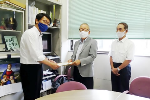 長崎市職員に書類を手渡している場面。