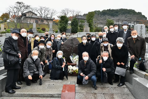 花が供えられた「原爆被害者の墓」の周囲に集まった参加者