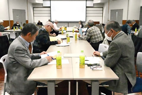 並べられた机に着席し、手元の資料を見ながら話を聞いている参加者たち。