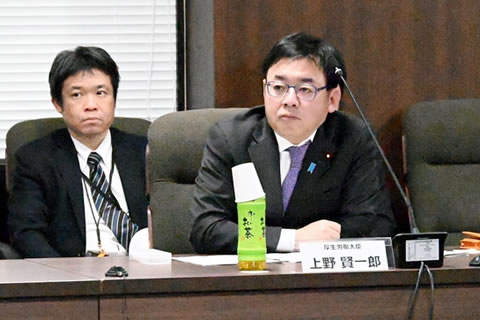 発言している人の方に顔を向けて話を聞いている様子の大臣。その後ろに座っている職員も同じ方向に目を向けている。