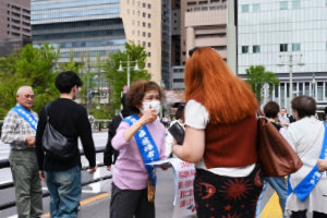 長方形に並べられた長机に、向き合う形で着席する参加者たち。机には紙の資料が配られている。