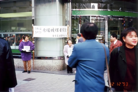 街頭で募金を訴えるキリスト者平和の会の人たち。「原爆被爆者救援」と書かれた横幕が掲げられている。