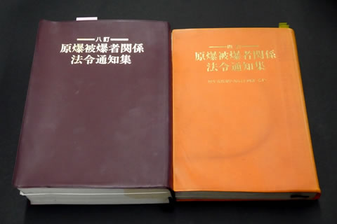 『原爆被爆者関係法令通知集』4訂版と8訂版を並べて置いた写真。